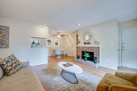 a living room with a fireplace and a couch and a table at Indian Creek Apartments, Texas